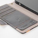 Etui cuir iPhone 17e / 16e - Flip Wallet en cuir véritable avec stripe design et compartiment à cartes - Noir